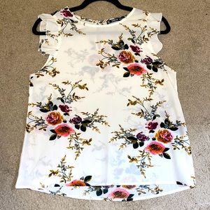 Sleeveless Blouse with ruffled shoulders and a beautiful floral print.
